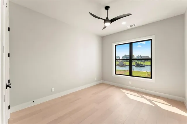 an empty room with window and ceiling fan