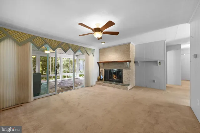 a view of a livingroom with a fireplace and a ceiling fan