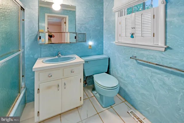 a bathroom with a toilet sink and mirror