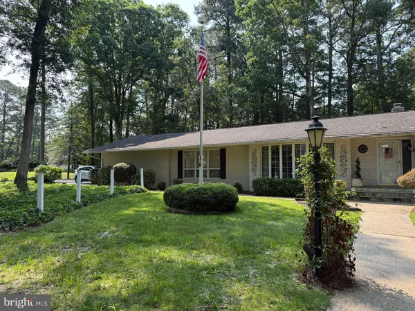 a front view of house with a garden and trees