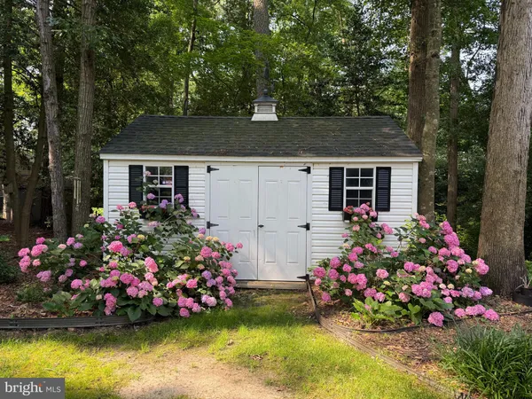 a view of front house with large garden and trees