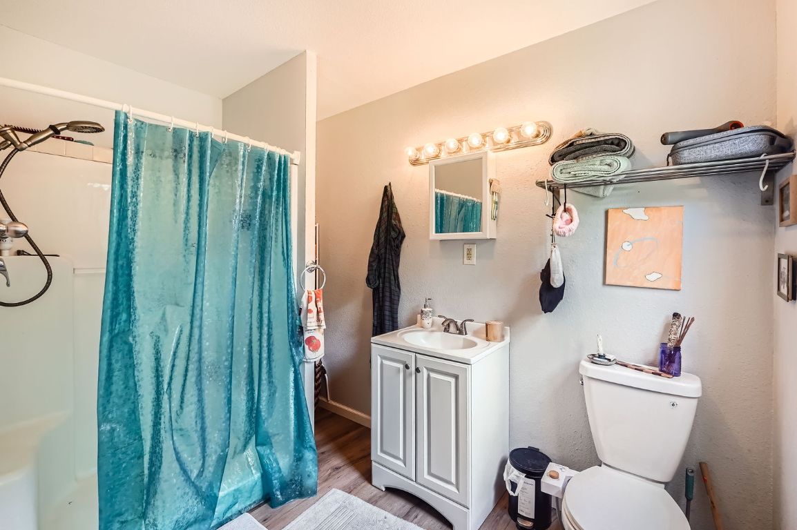 5605 Tura Lane Austin, TX 78721 - Photo 6 of 11 Full bath with vanity, wood finished floors, and a shower with shower curtain