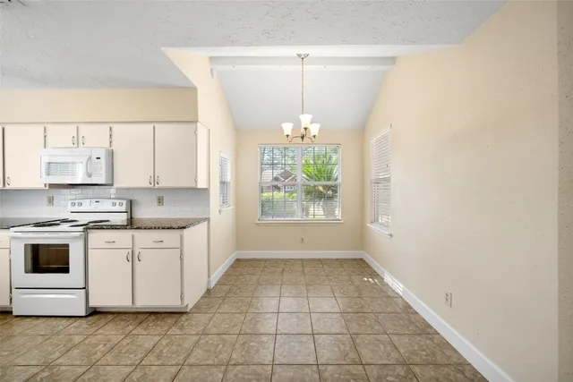 a kitchen with a white cabinets and window