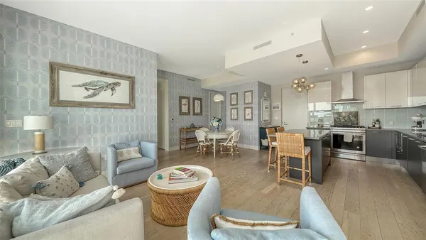 a living room with furniture wooden floor and kitchen view