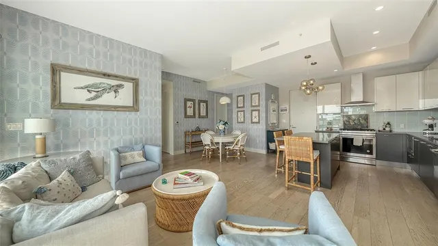 a living room with furniture wooden floor and kitchen view