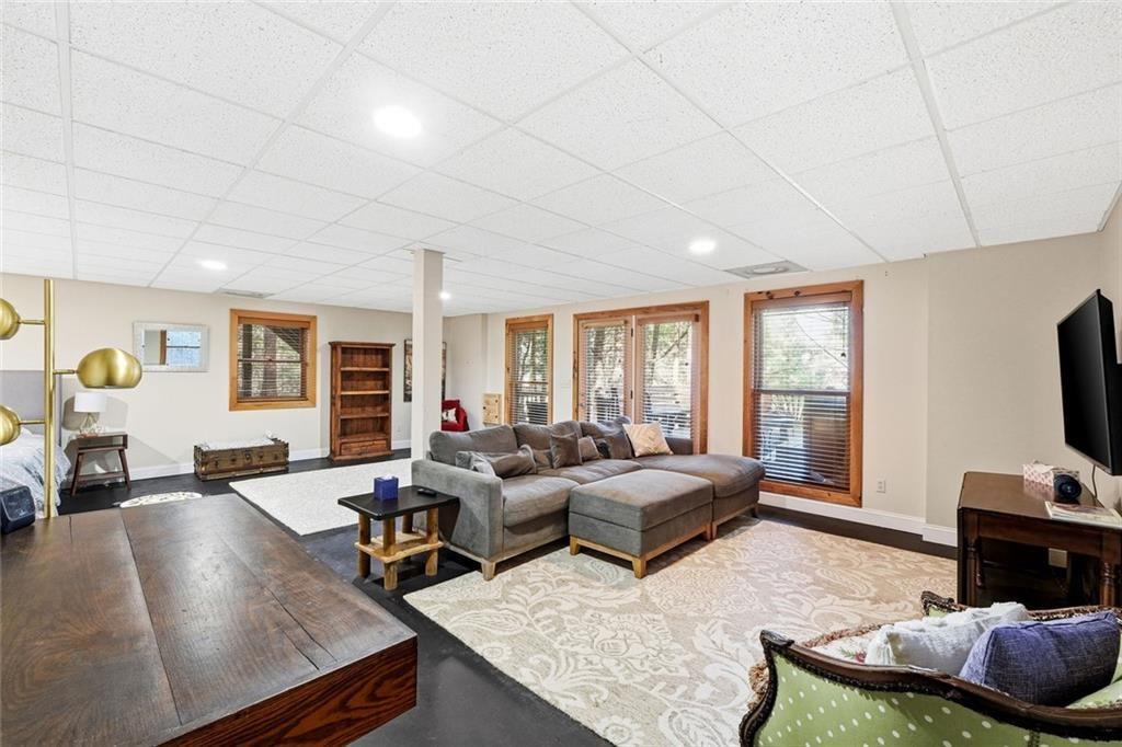 834 Indian Cave Road Ellijay, GA 30536 - Photo 23 of 44 a living room with furniture a flat screen tv and a large window