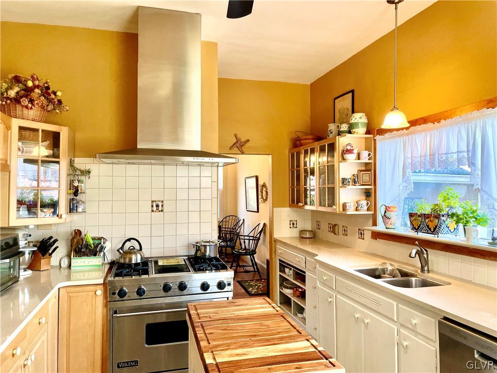 2030 Park Road Easton, PA 18045 - Photo 14 of 40 a kitchen with stainless steel appliances a stove a sink dishwasher and white cabinets with wooden floor