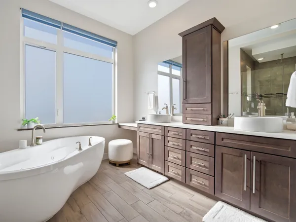 a bathroom with a double vanity sink a mirror and a bathtub