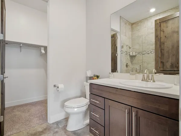 a bathroom with a granite countertop sink a toilet and a mirror