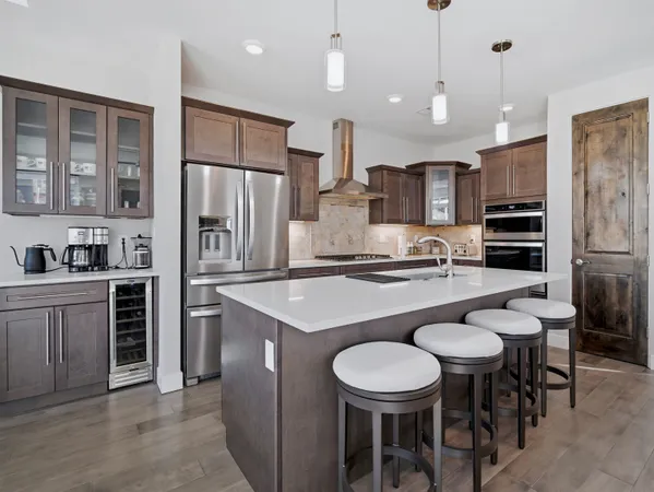 a kitchen with stainless steel appliances granite countertop a sink and a refrigerator