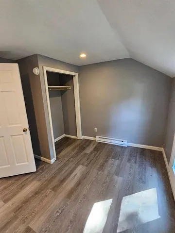 an empty room with wooden floor and entrance