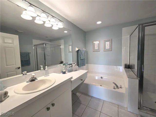 a bathroom with a tub double sink and mirror