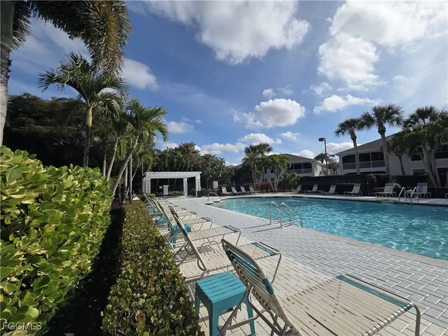 a view of a swimming pool with a lounge chair and floor to ceiling window
