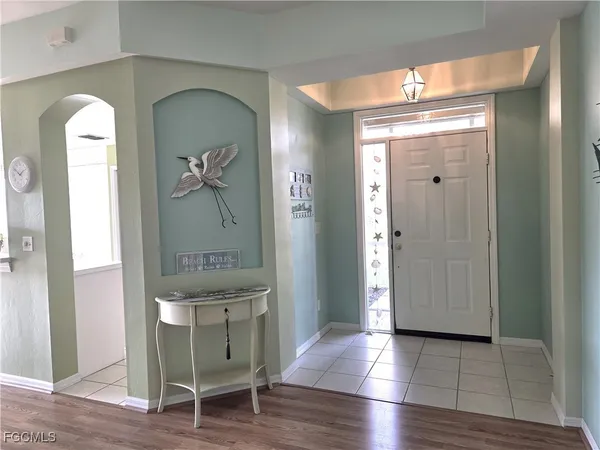 a view of a hallway with wooden floor and mirror