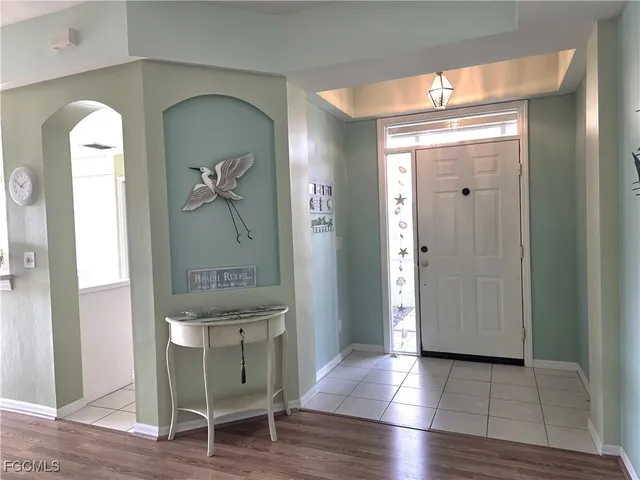 a view of a hallway with wooden floor and mirror
