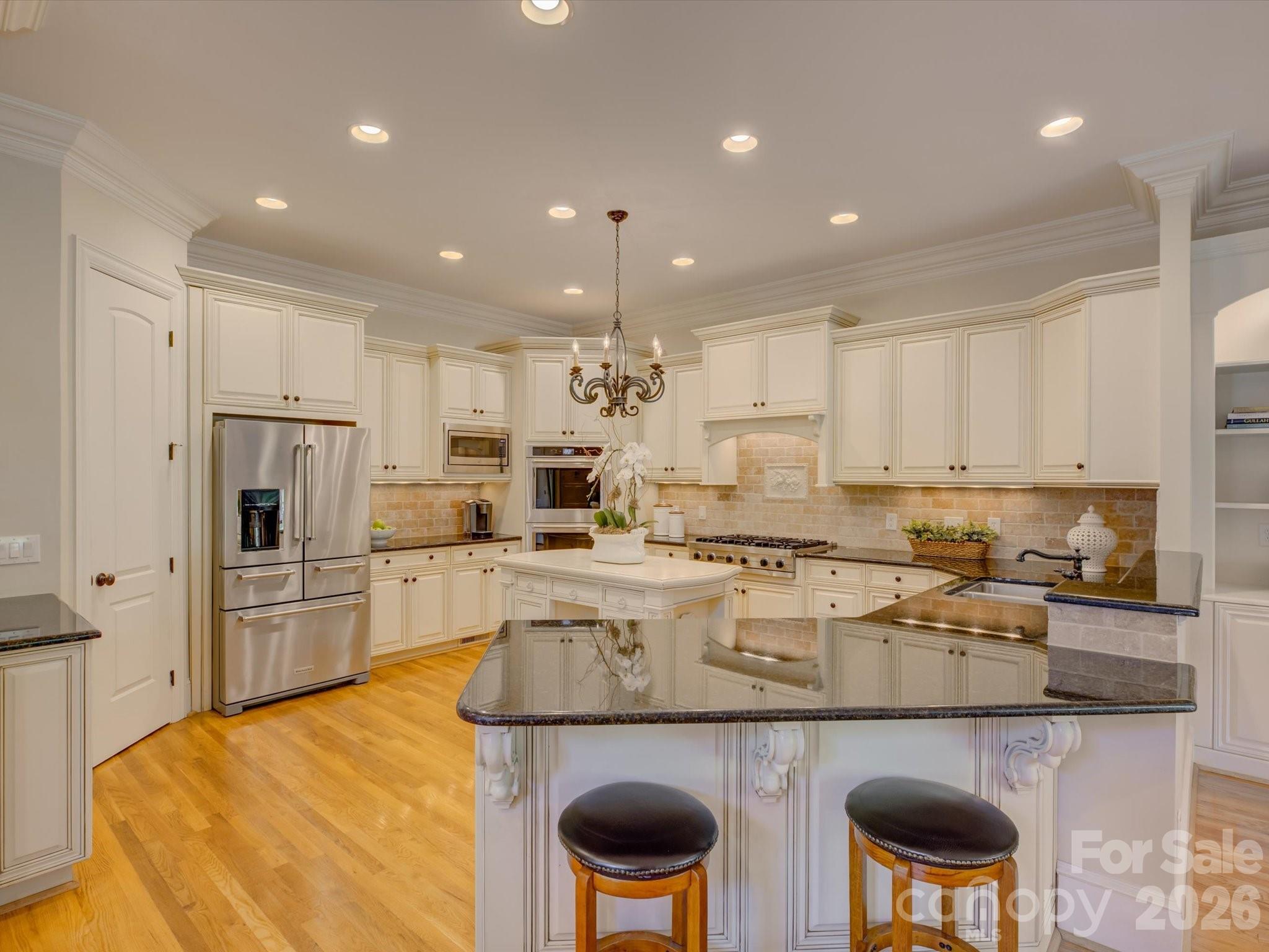 5060 Carmel Road Charlotte, NC 28226 - Photo 11 of 46 a kitchen with stainless steel appliances granite countertop a stove and white cabinets