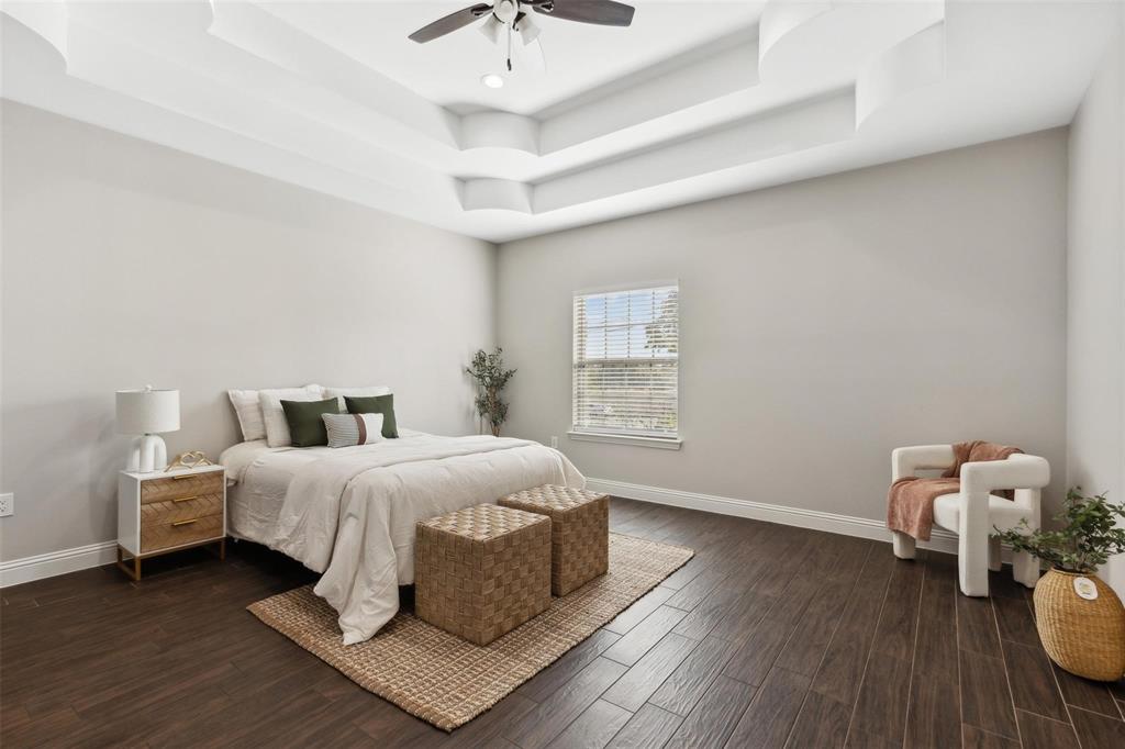 4662 Barbara Road River Oaks, TX 76114 - Photo 8 of 14 Tray ceiling with layered design, ceiling fan with integrated lighting, wood-finish flooring, and a window with blinds
