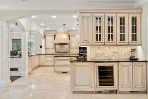 a kitchen with stainless steel appliances granite countertop a stove and white cabinets