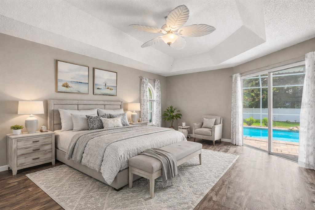 14717 Linden Drive Spring Hill, FL 34609 - Photo 12 of 29 a bedroom with a large bed and a chandelier