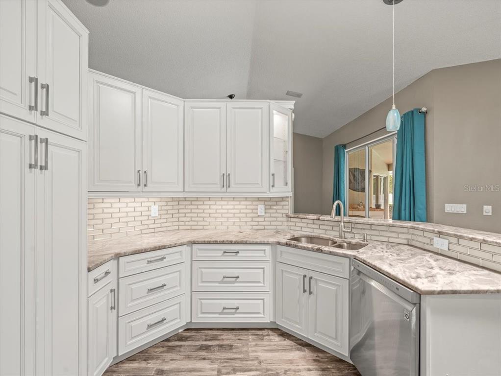 14717 Linden Drive Spring Hill, FL 34609 - Photo 7 of 29 a kitchen with granite countertop white cabinets and white appliances