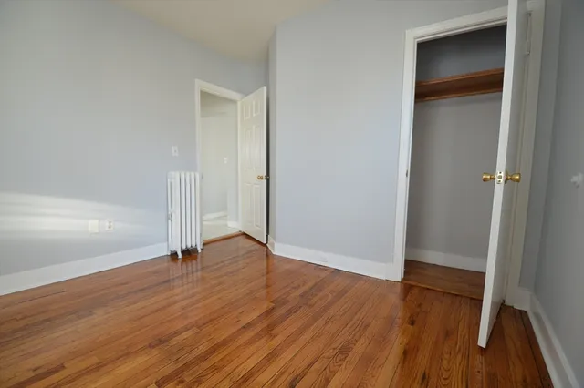 an empty room with wooden floor and closet