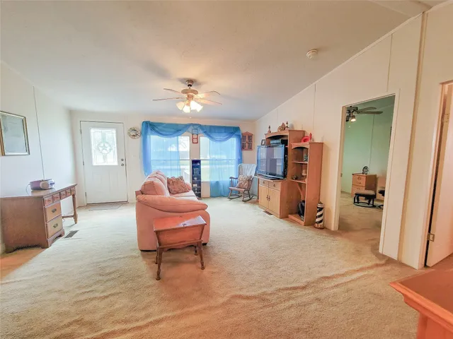 a living room with furniture and a dining table with kitchen view