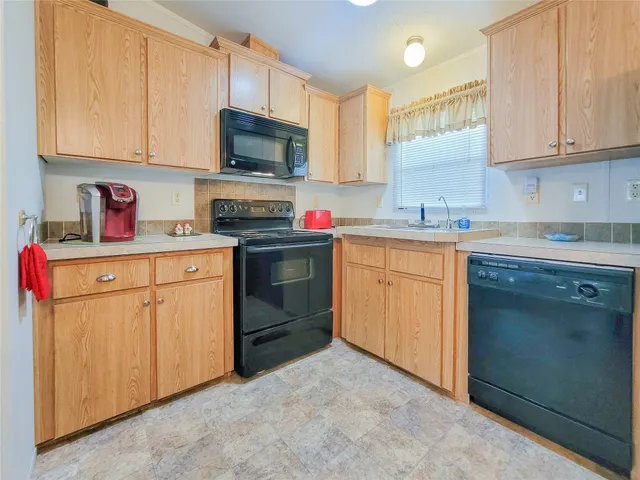 a kitchen with cabinets stainless steel appliances and sink
