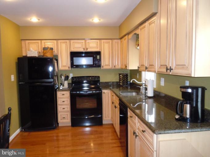 1079 Downton Road Halethorpe, MD 21227 - Photo 9 of 26 a kitchen with stainless steel appliances granite countertop a refrigerator a stove a sink and a microwave