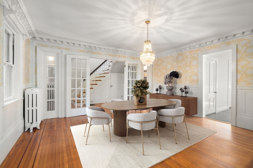 324 Union Street, Unit 1 Millis, MA 02054 - Photo 3 of 29 a dining room with wooden floor a chandelier a wooden table and chairs