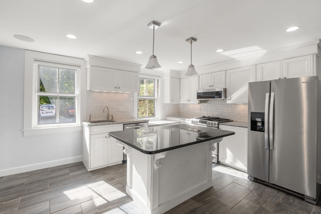 324 Union Street, Unit 1 Millis, MA 02054 - Photo 7 of 29 a kitchen with stainless steel appliances granite countertop a sink stove and refrigerator