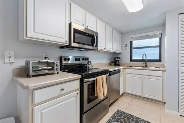 a kitchen with white cabinets stainless steel appliances and sink