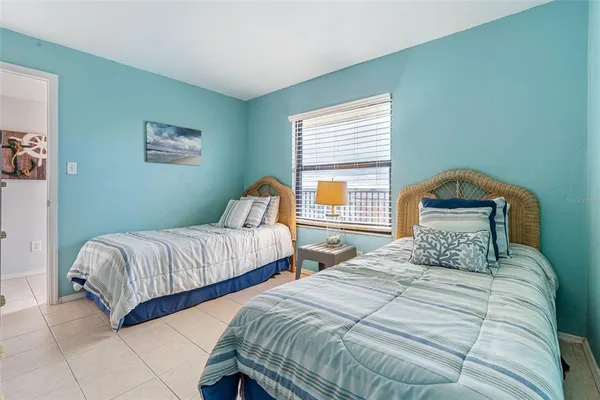 a bedroom with two beds and a window