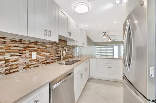 a kitchen with cabinets stainless steel appliances a sink and wooden floor