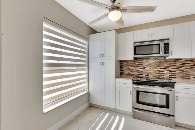 a view of an empty room with closet and a window