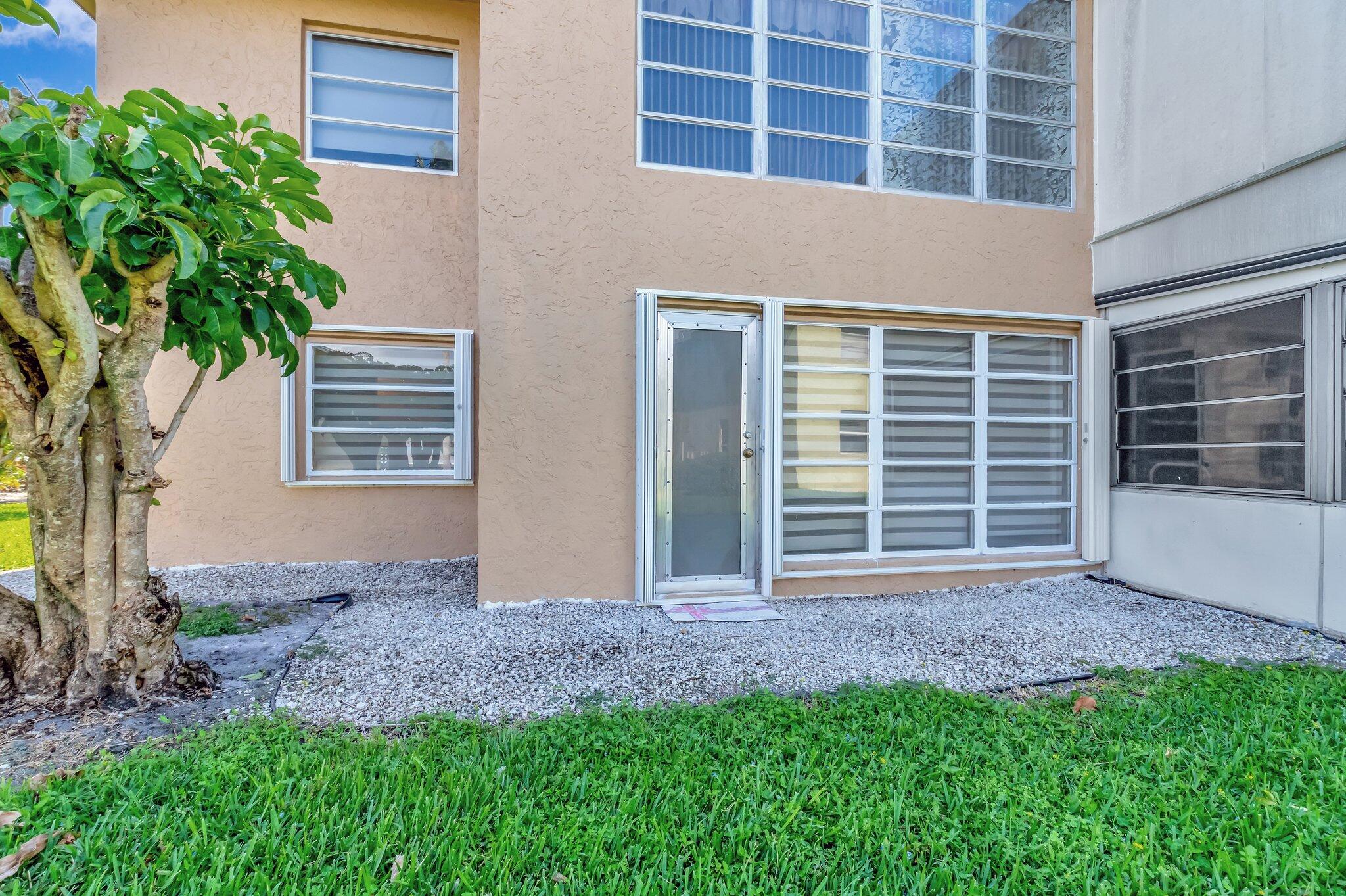 1131 Violet Terrace, Unit 104 Delray Beach, FL 33445 - Photo 25 of 36 a view of house with backyard space and balcony