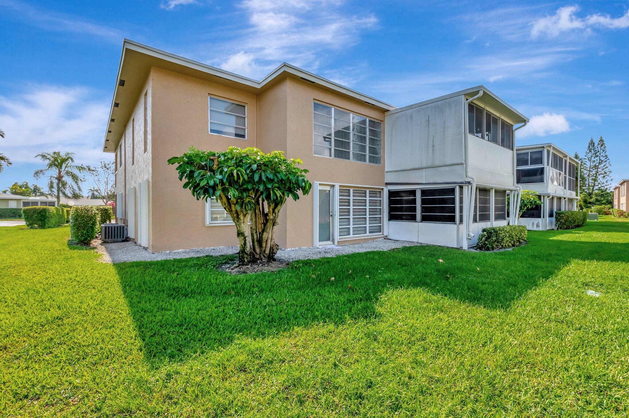 1131 Violet Terrace, Unit 104 Delray Beach, FL 33445 - Photo 26 of 36 a front view of a house with a yard