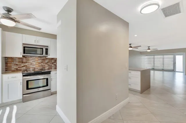 a kitchen with granite countertop white cabinets and window
