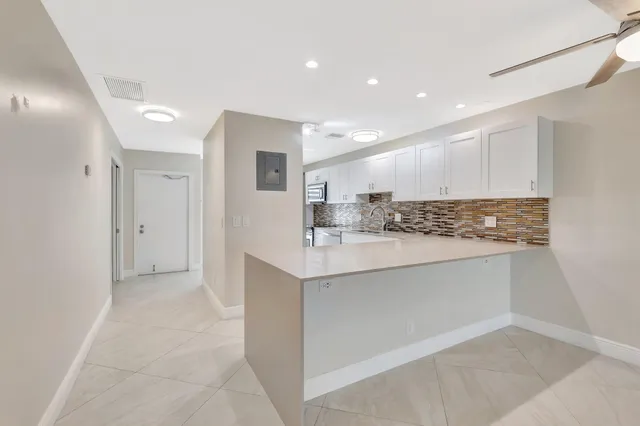 a kitchen with granite countertop white cabinets and white appliances