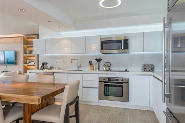 a kitchen with stainless steel appliances granite countertop a stove a sink and a refrigerator