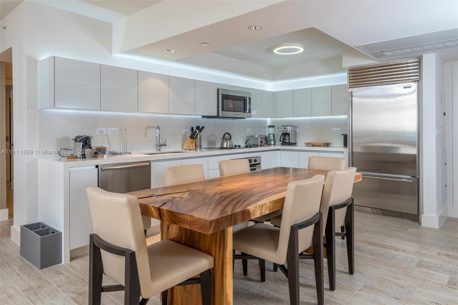 102 24th Street, Unit 1015 Miami Beach, FL 33139 - Photo 2 of 20 a dining room with a table chairs and a refrigerator