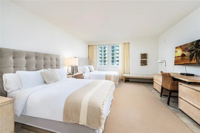 a bed room with two bed and a television