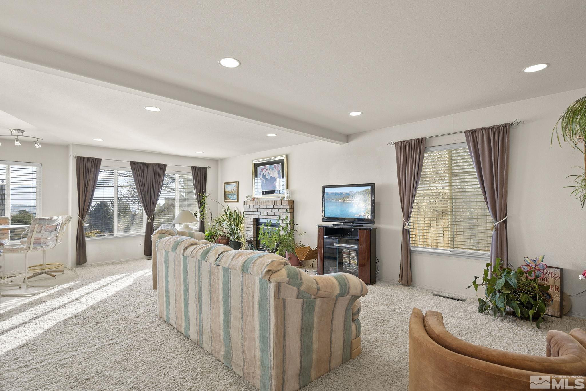 5364 Tappan Court Reno, NV 89523 - Photo 11 of 40 a living room with furniture a flat screen tv and a floor to ceiling window