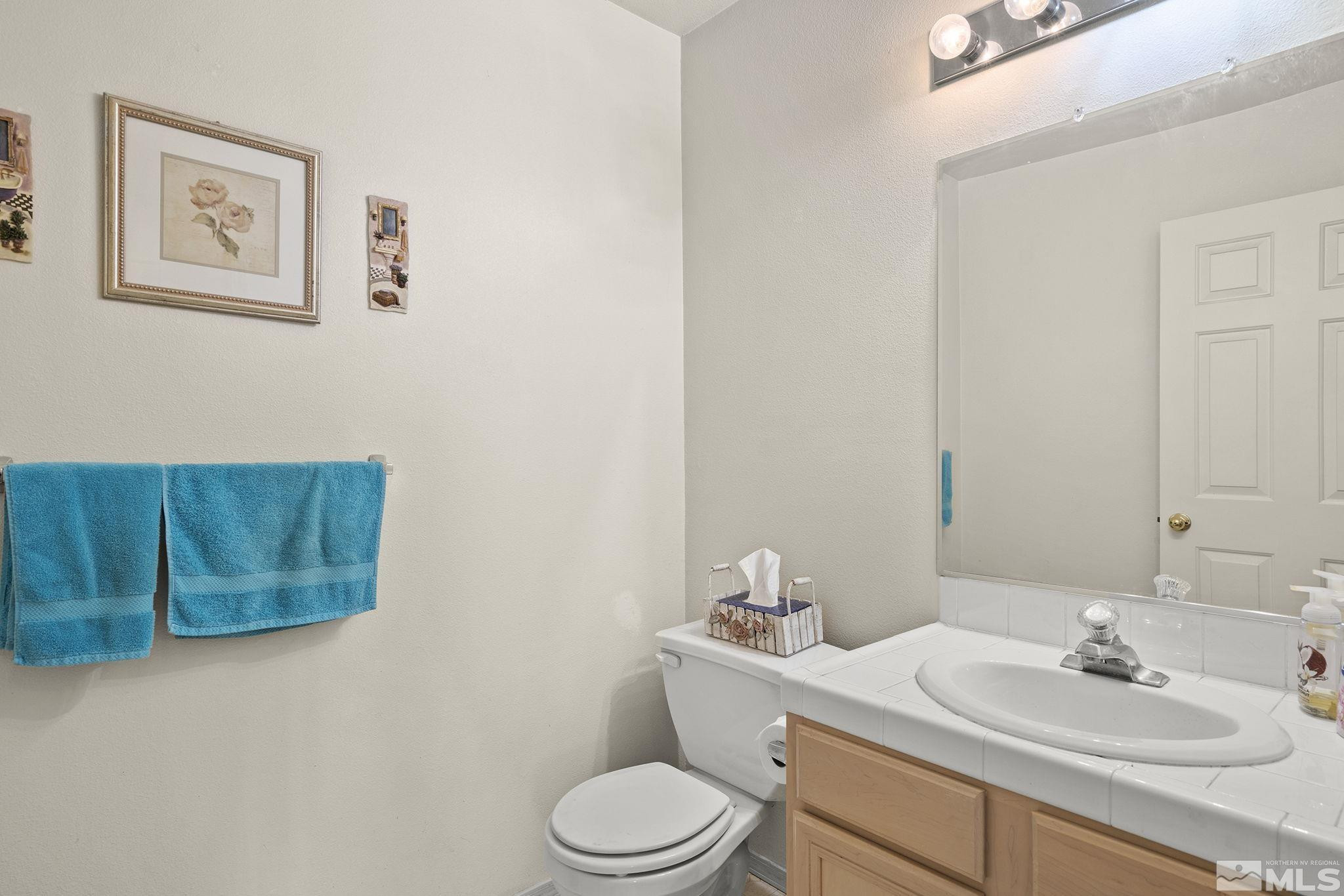 5364 Tappan Court Reno, NV 89523 - Photo 19 of 40 a bathroom with a toilet a sink and mirror