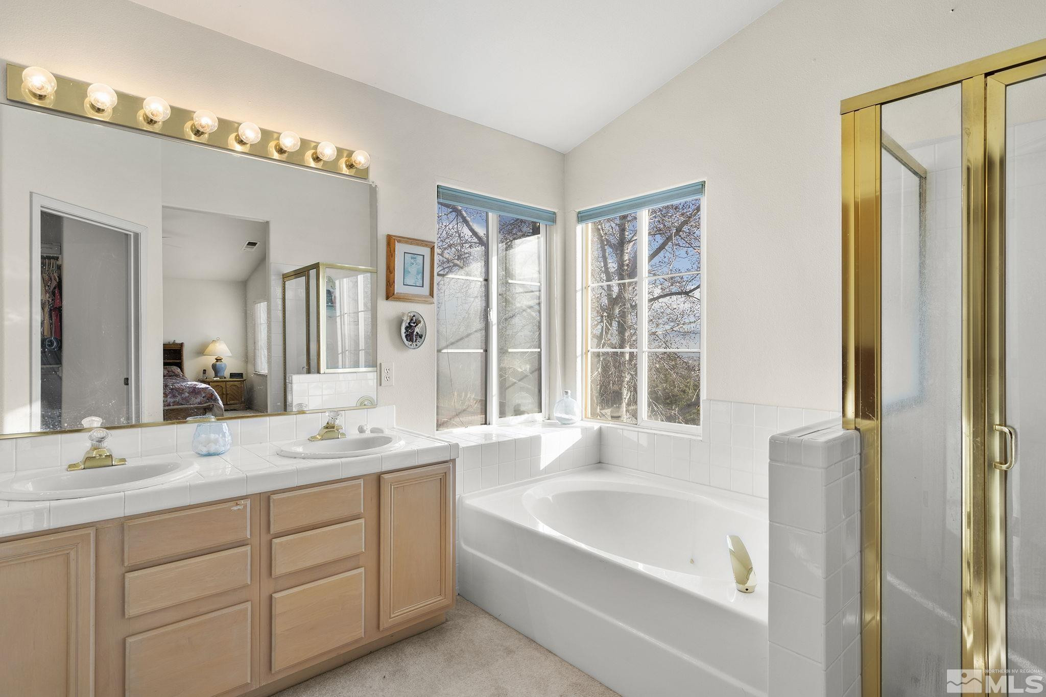 5364 Tappan Court Reno, NV 89523 - Photo 22 of 40 a en suite bathroom with a double vanity sink a mirror and a bathtub