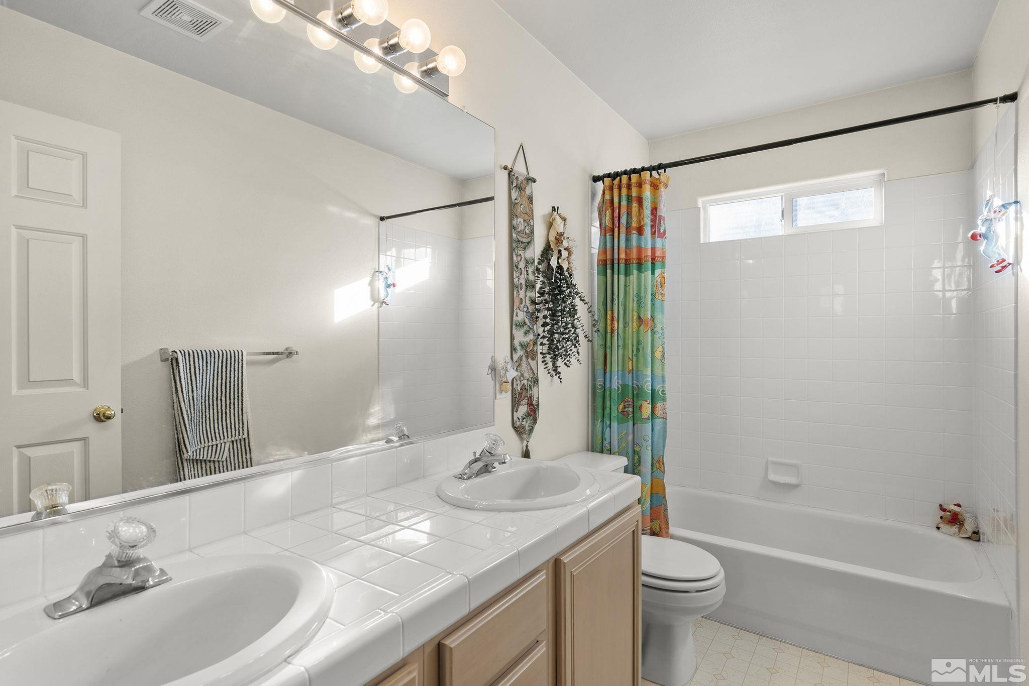 5364 Tappan Court Reno, NV 89523 - Photo 27 of 40 a bathroom with a granite countertop sink a toilet and shower