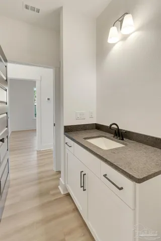 a bathroom with a granite countertop sink and a mirror