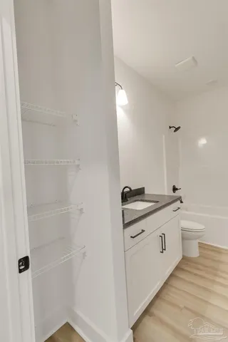 a bathroom with a granite countertop sink a toilet and a shower