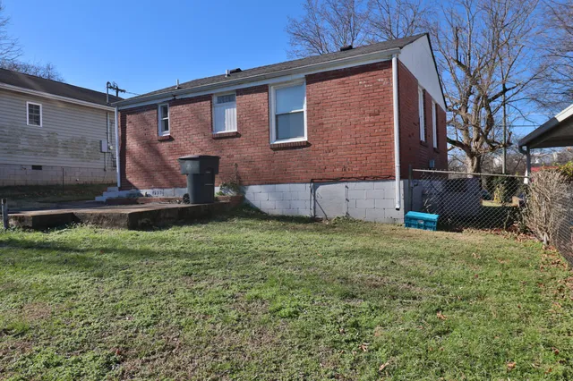 a brick house with a yard and pathway
