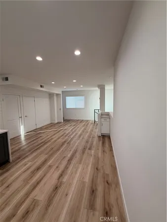 a view of a hallway with wooden floor and staircase