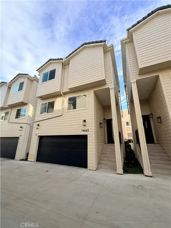 a view of a house with a door and a car parked in garage